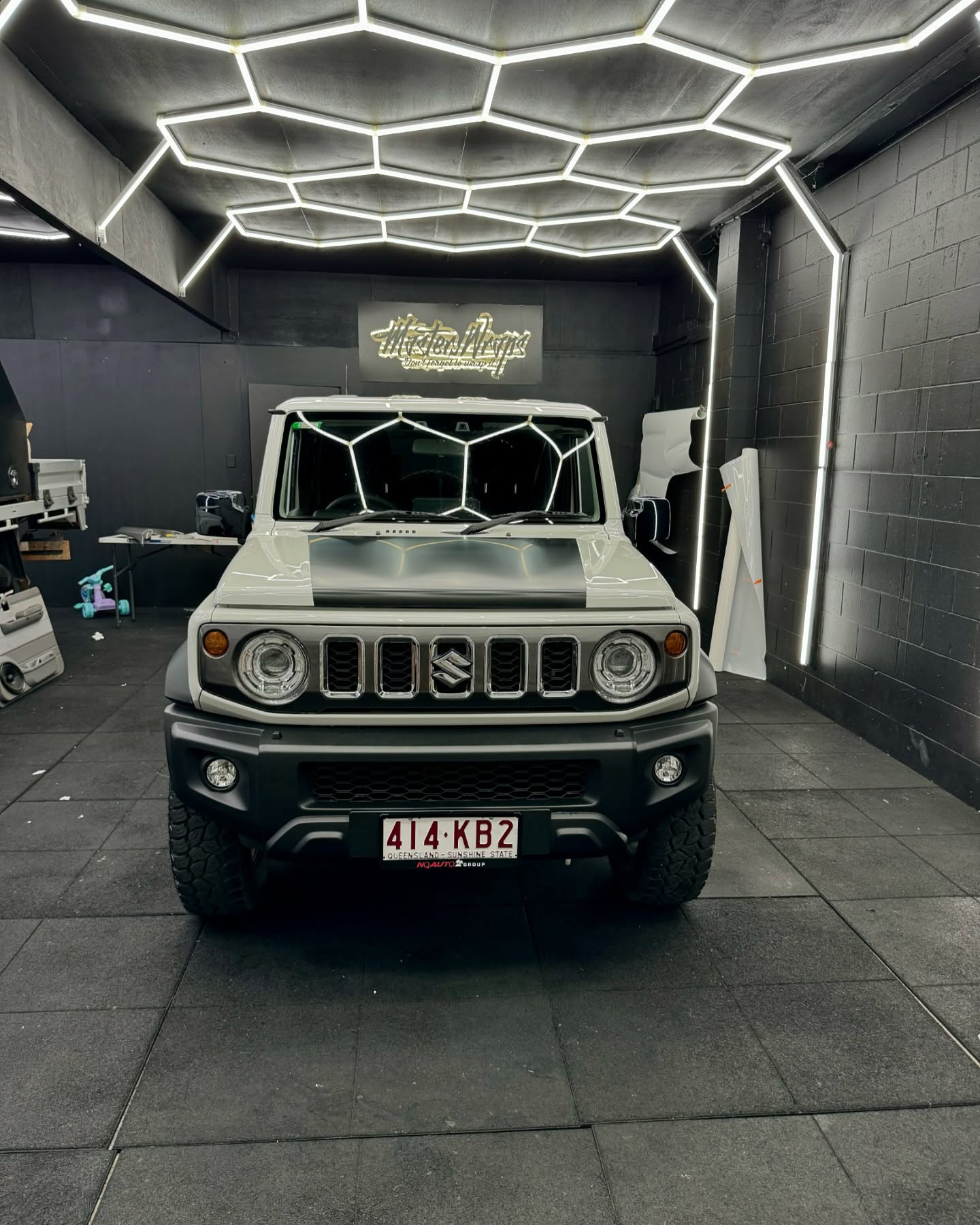 Grey Suzuki Jimny with black hood wrap front view inside the Master Wraps studio