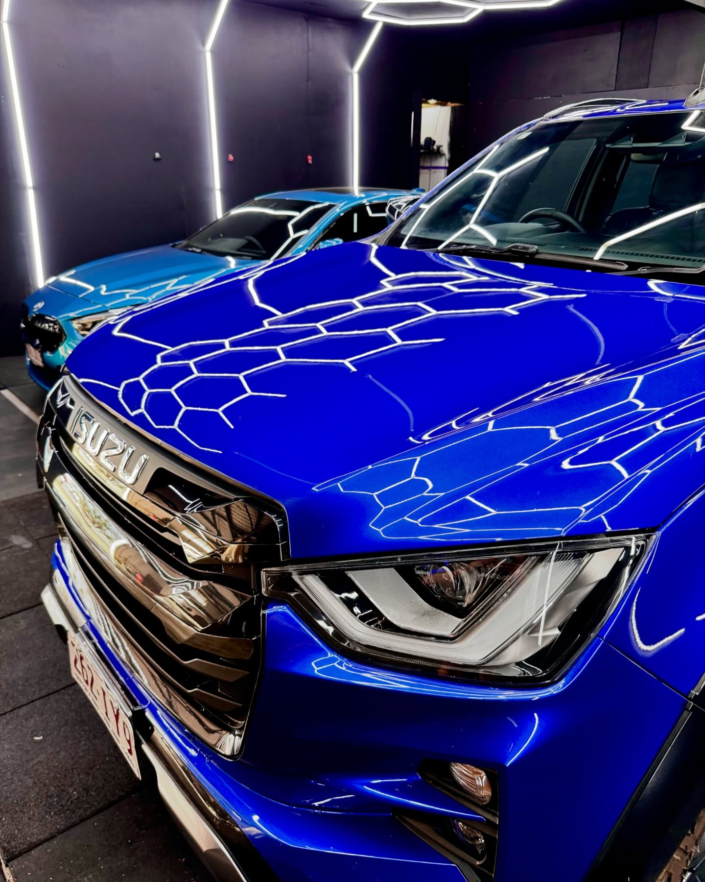 Gloss blue Isuzu D-Max front hood detail showing premium finish