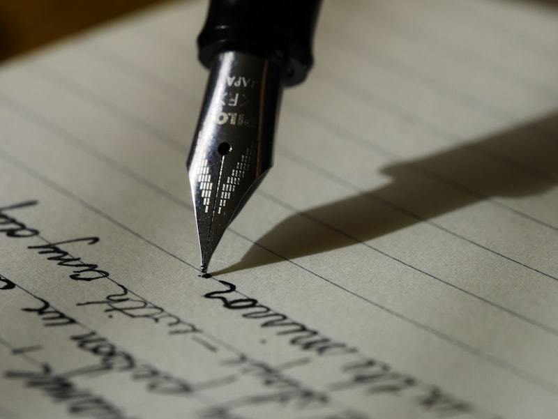 Author writing a manuscript at a desk with notebook and pen, Inkspire Literary Studio writing resources