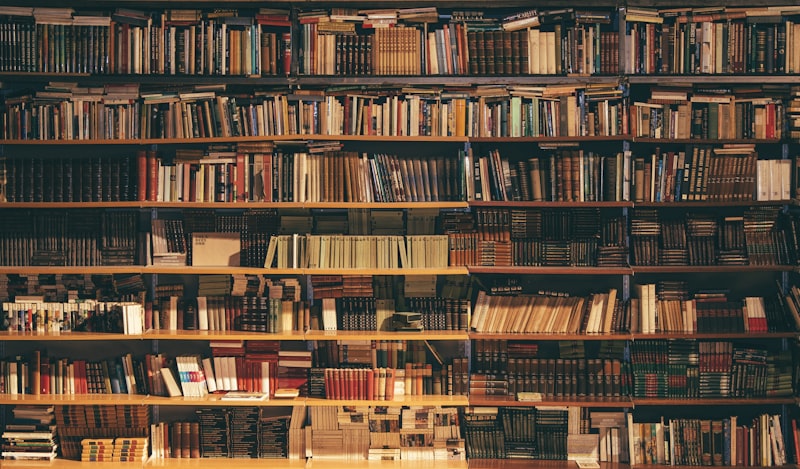Stack of published books on a wooden table in a library, Inkspire Literary Studio publishing education
