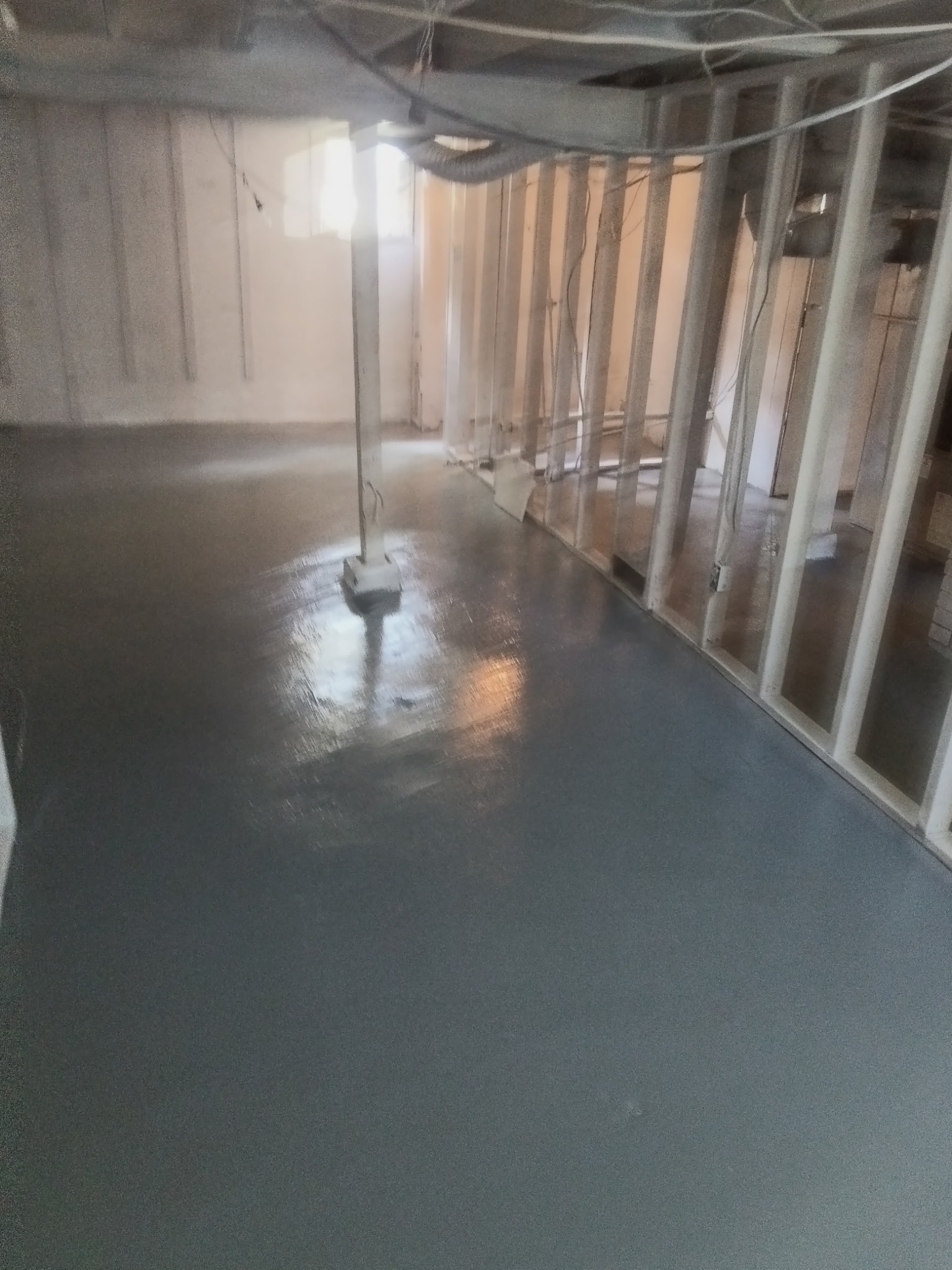 High-gloss sealed basement floor and wall studs in South Central
