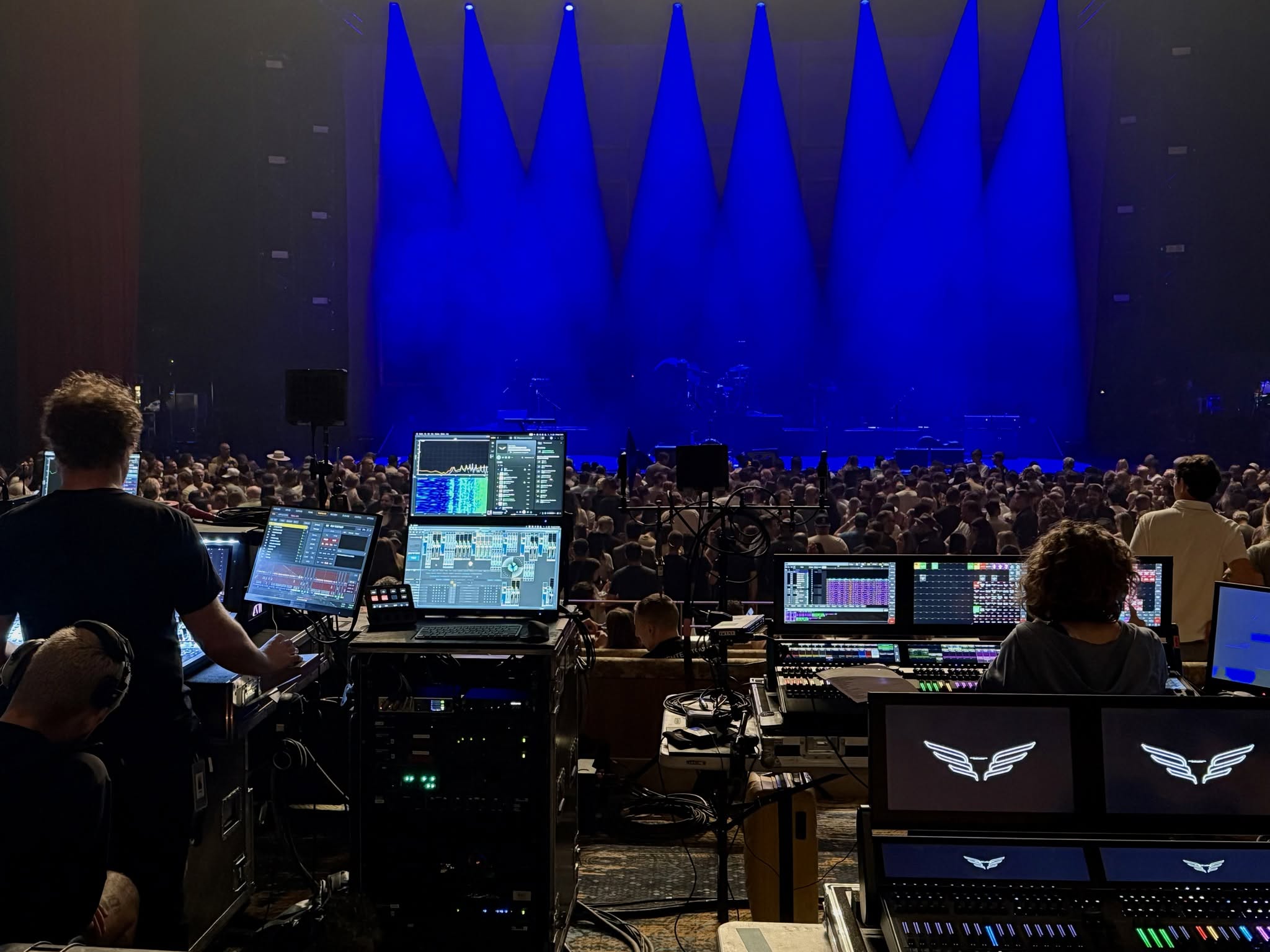 View from the soundboard during the Mumford & Sons concert showing the packed venue under blue stage lights