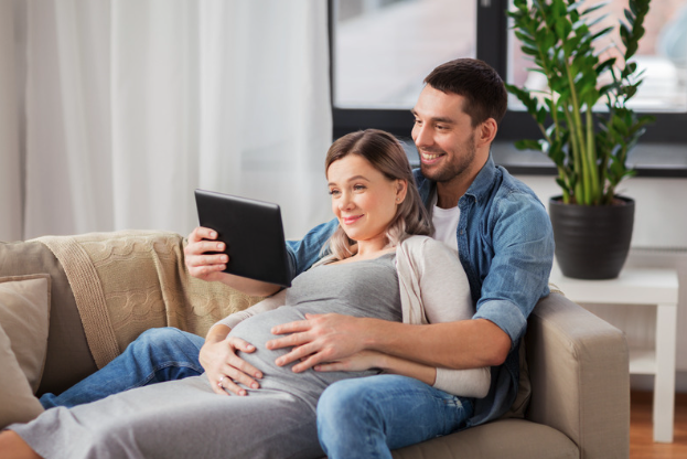 Expectant parents viewing prenatal education together on a tablet.