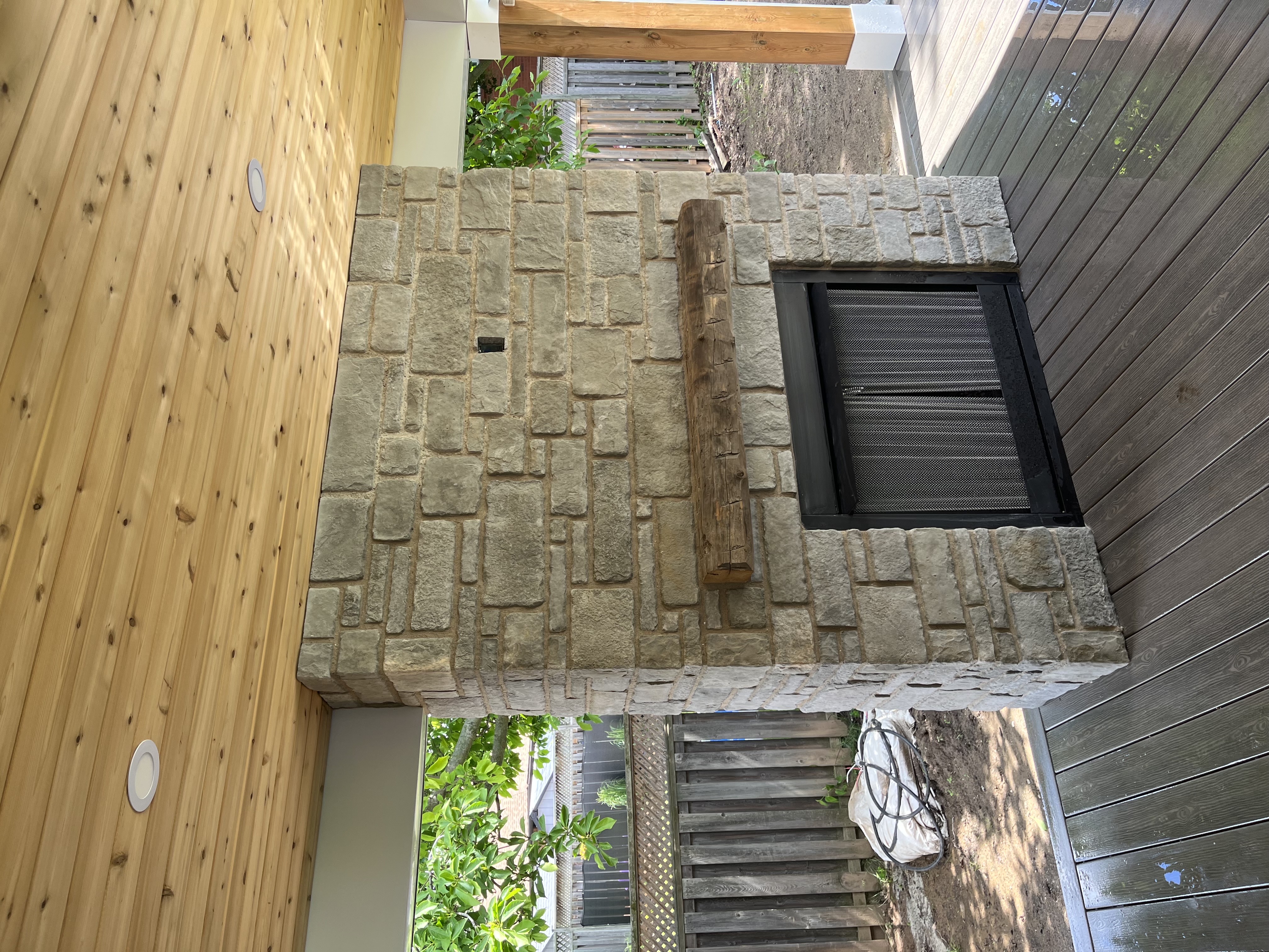 Custom limestone outdoor fireplace built by Solitary Stone in Hamilton Ontario