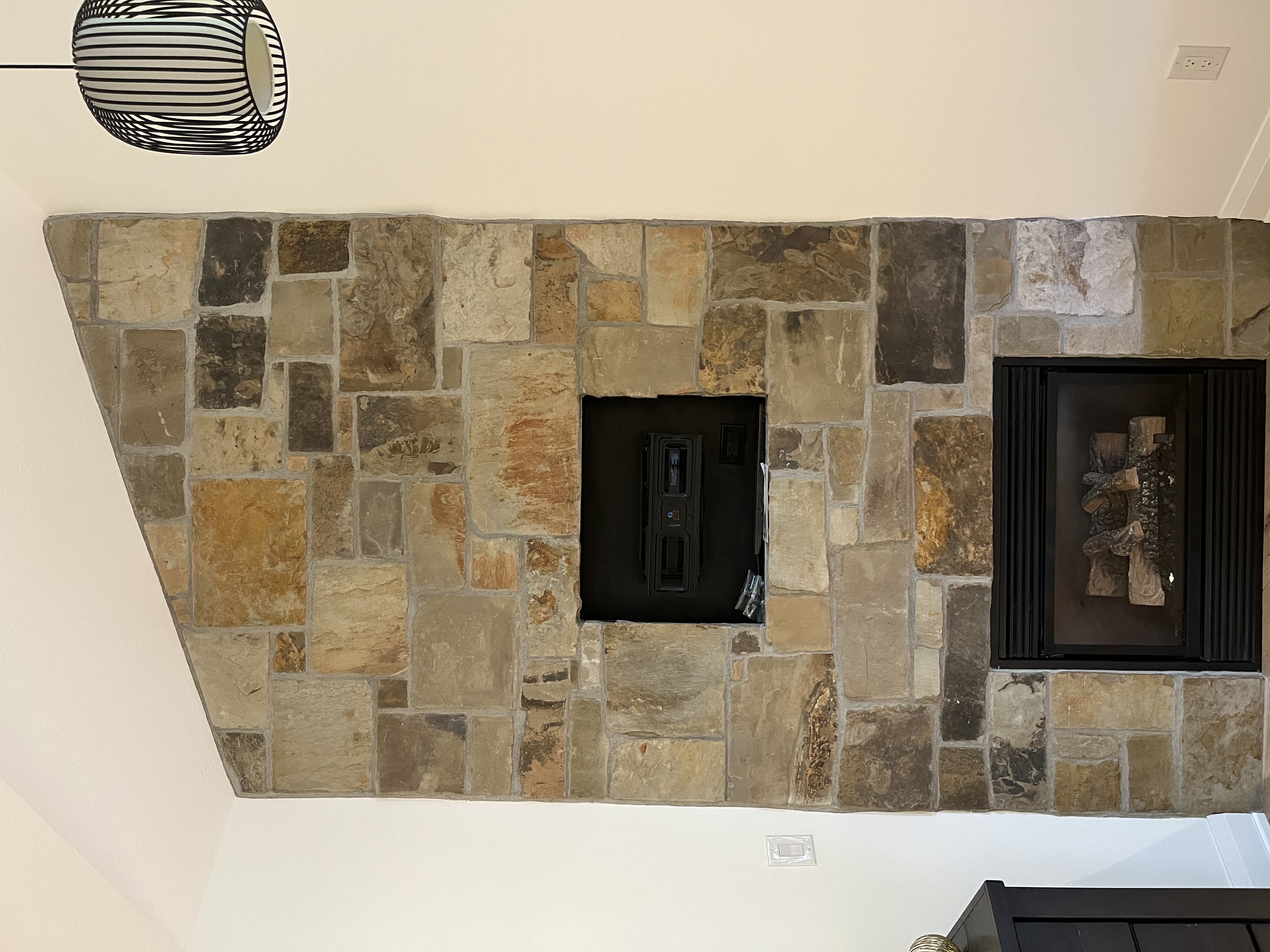Natural stone fireplace surround with floor-to-ceiling installation