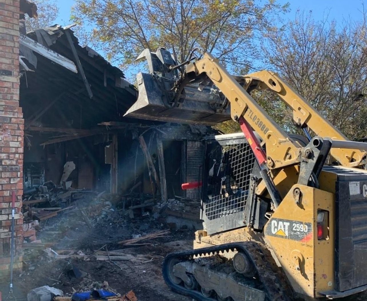 Ayala Demolition skid steer tearing down a house