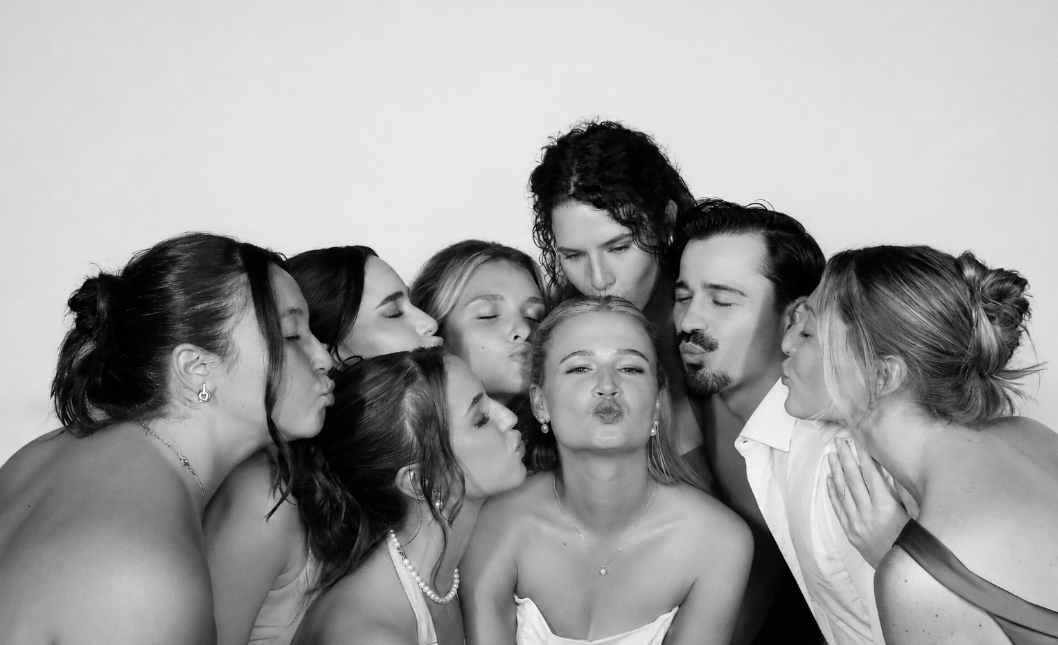 Black-and-white wedding photobooth group photo with guests celebrating