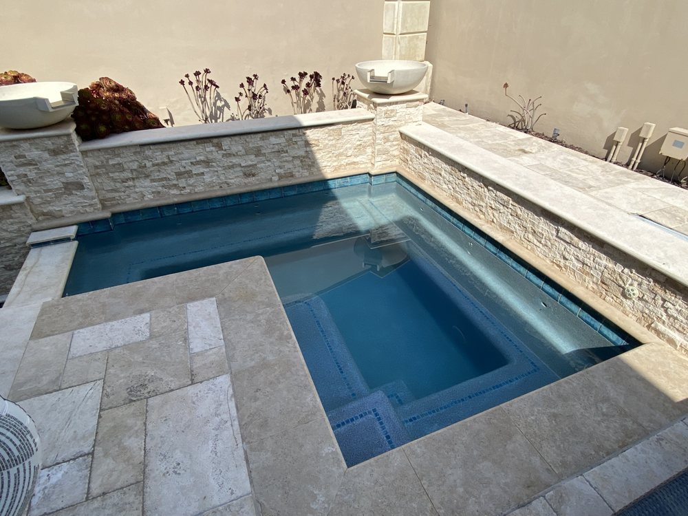 Spa being skimmed and brushed during a scheduled spa cleaning service