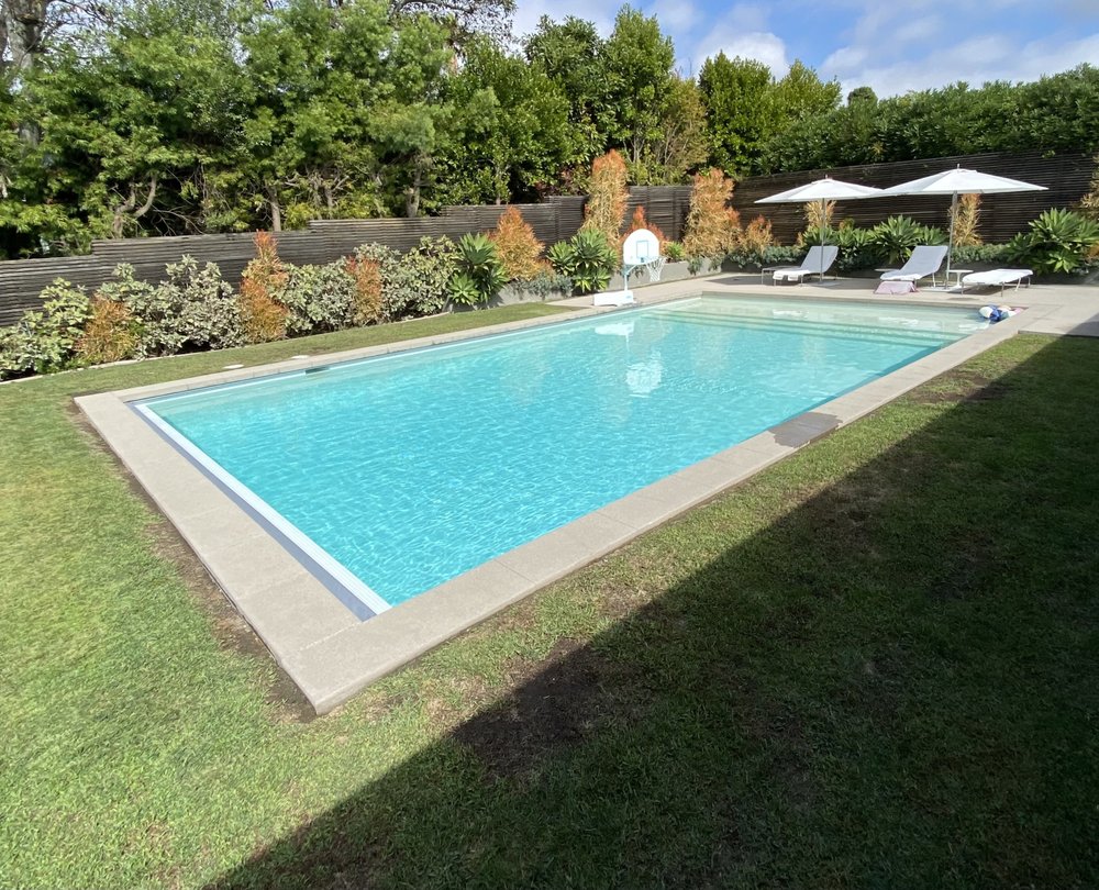 Backyard swimming pool with clear blue water and tidy tile line after weekly maintenance in Torrance