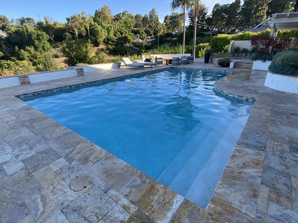 Wide view of a clean residential pool with a clear surface and brushed walls