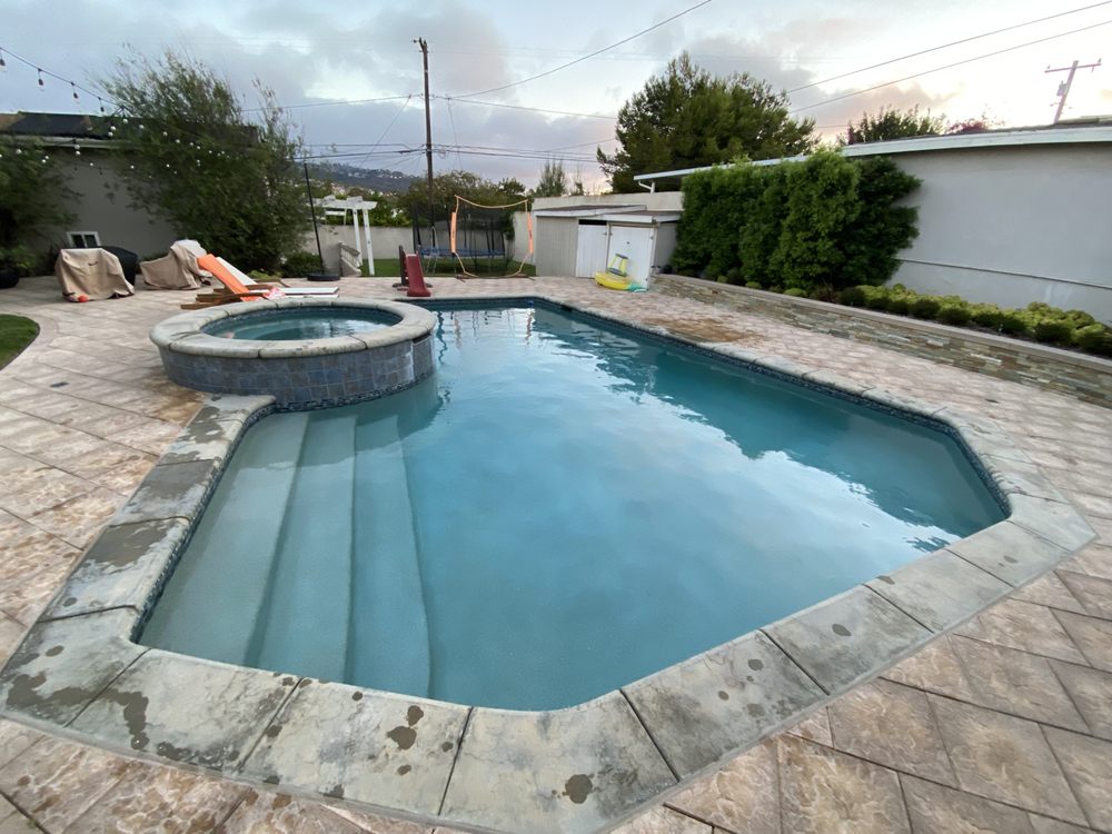 Pool with an attached spa, both freshly cleaned and ready to use