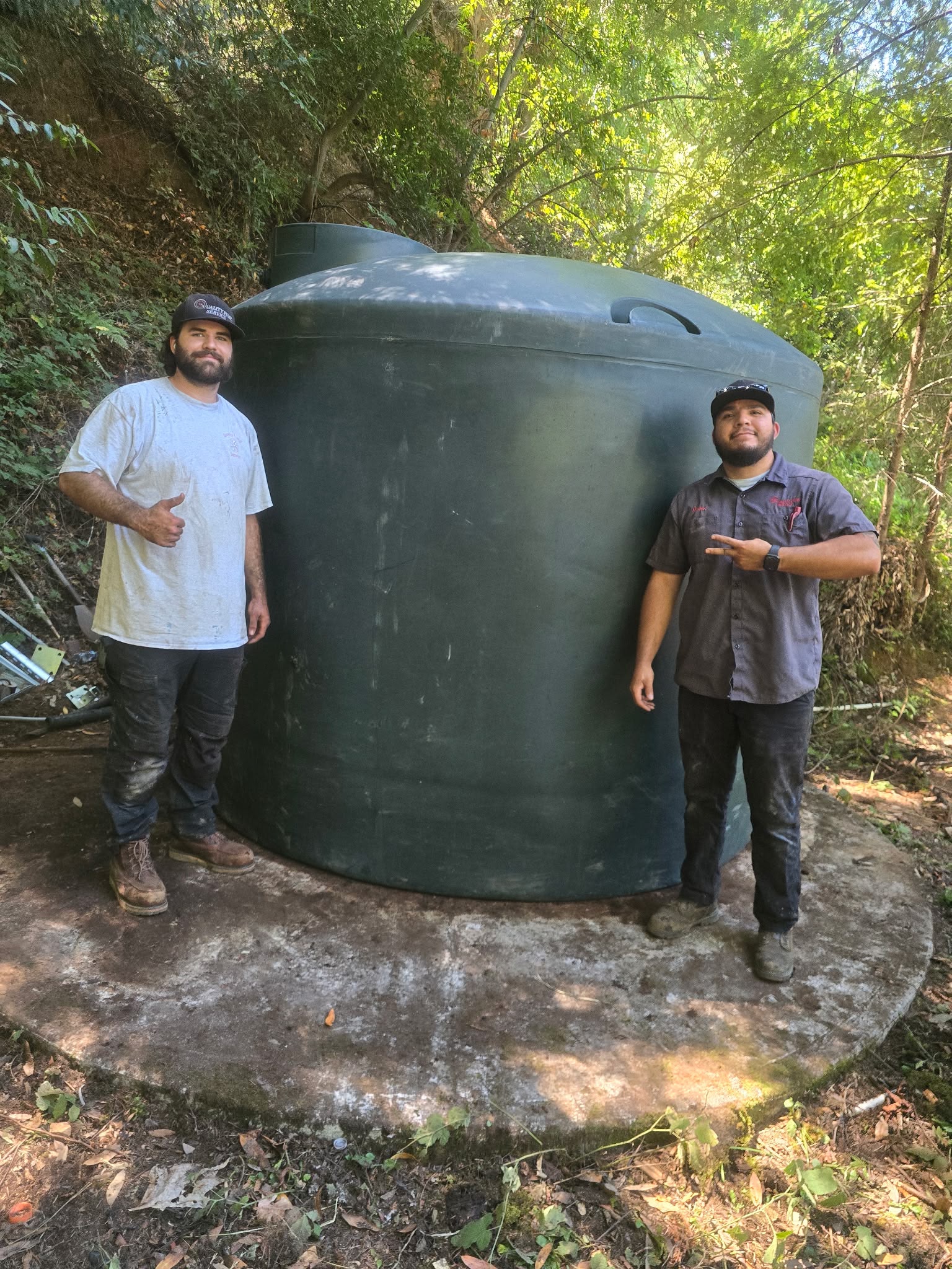 Quality Pump Service technicians with installed water storage tank in the SF Bay Area
