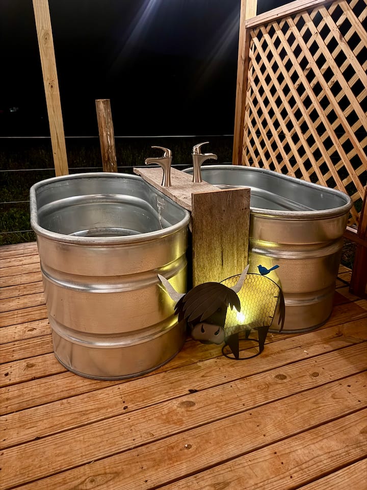 Outdoor soaking tubs under string lights at Faith Farm