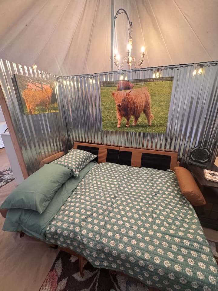Inviting king bed inside Dolly's Dream Den glamping tent
