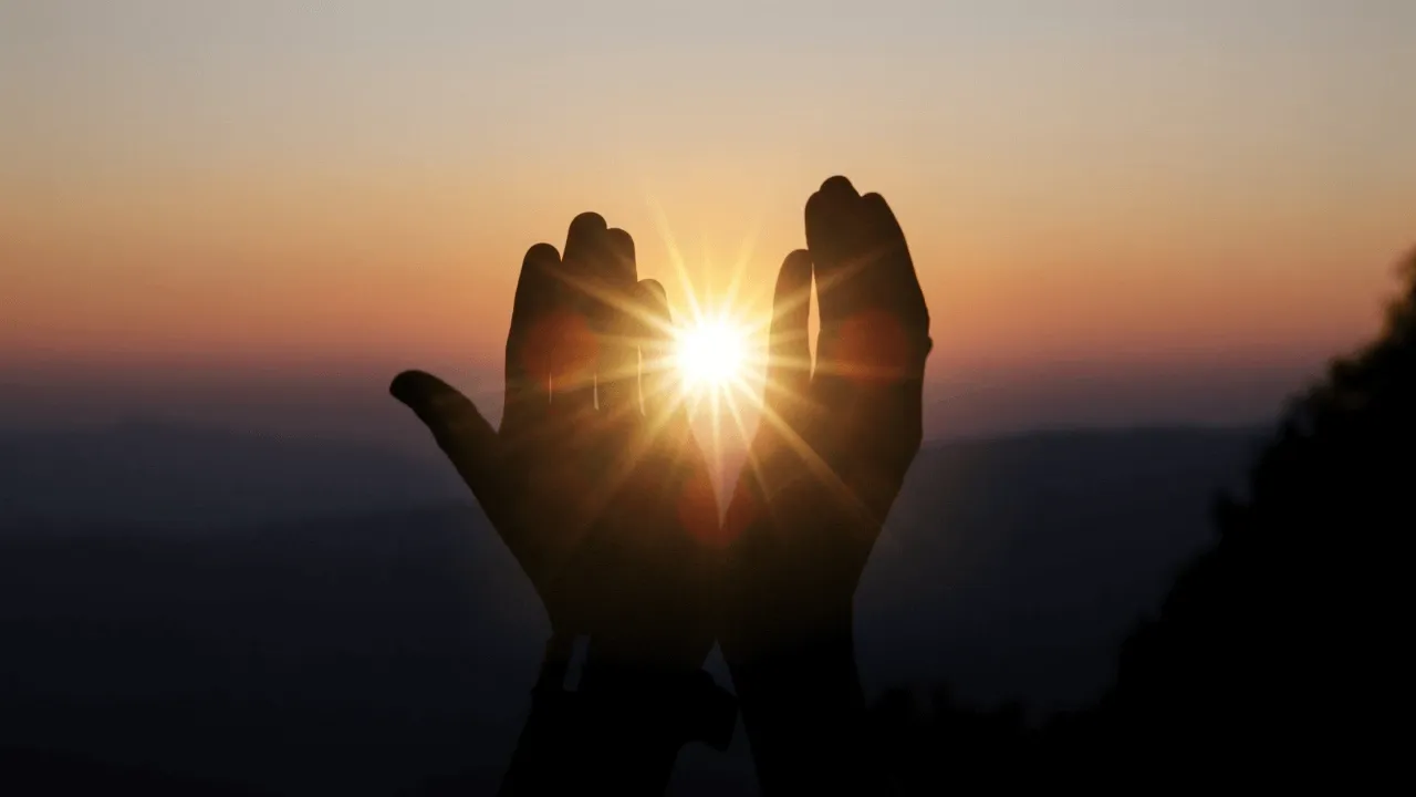 Spiritual prayer hands capturing a sunset