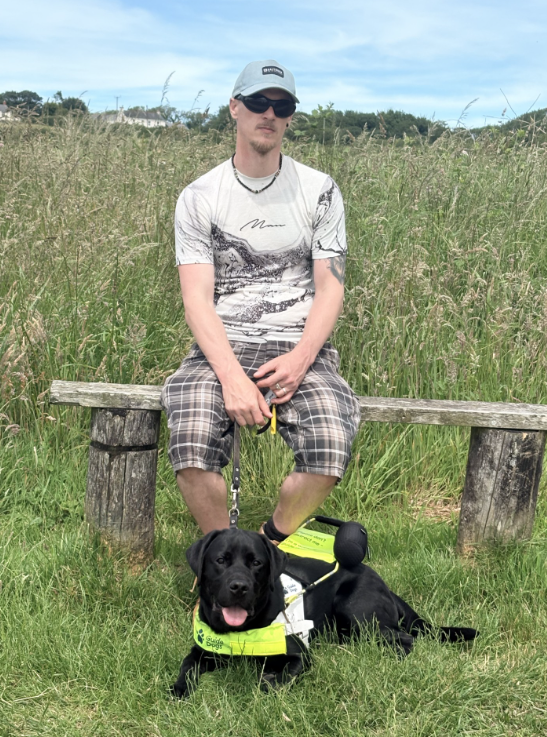 Daniel sitting on bench with dog