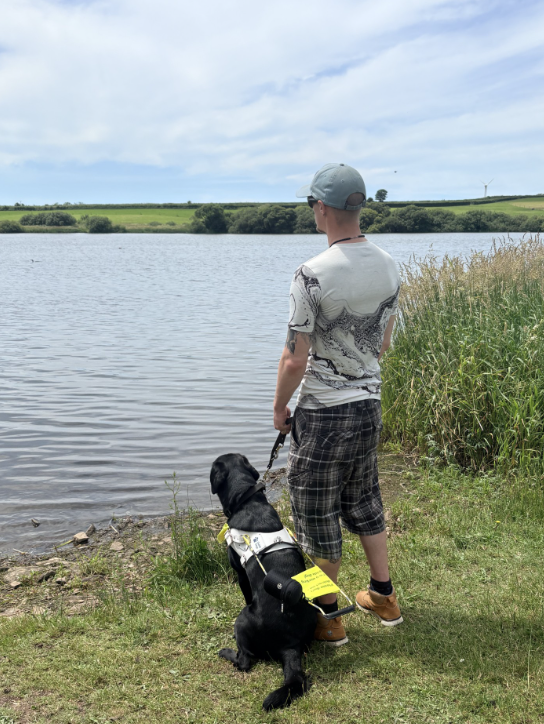 Daniel looking at water with dog