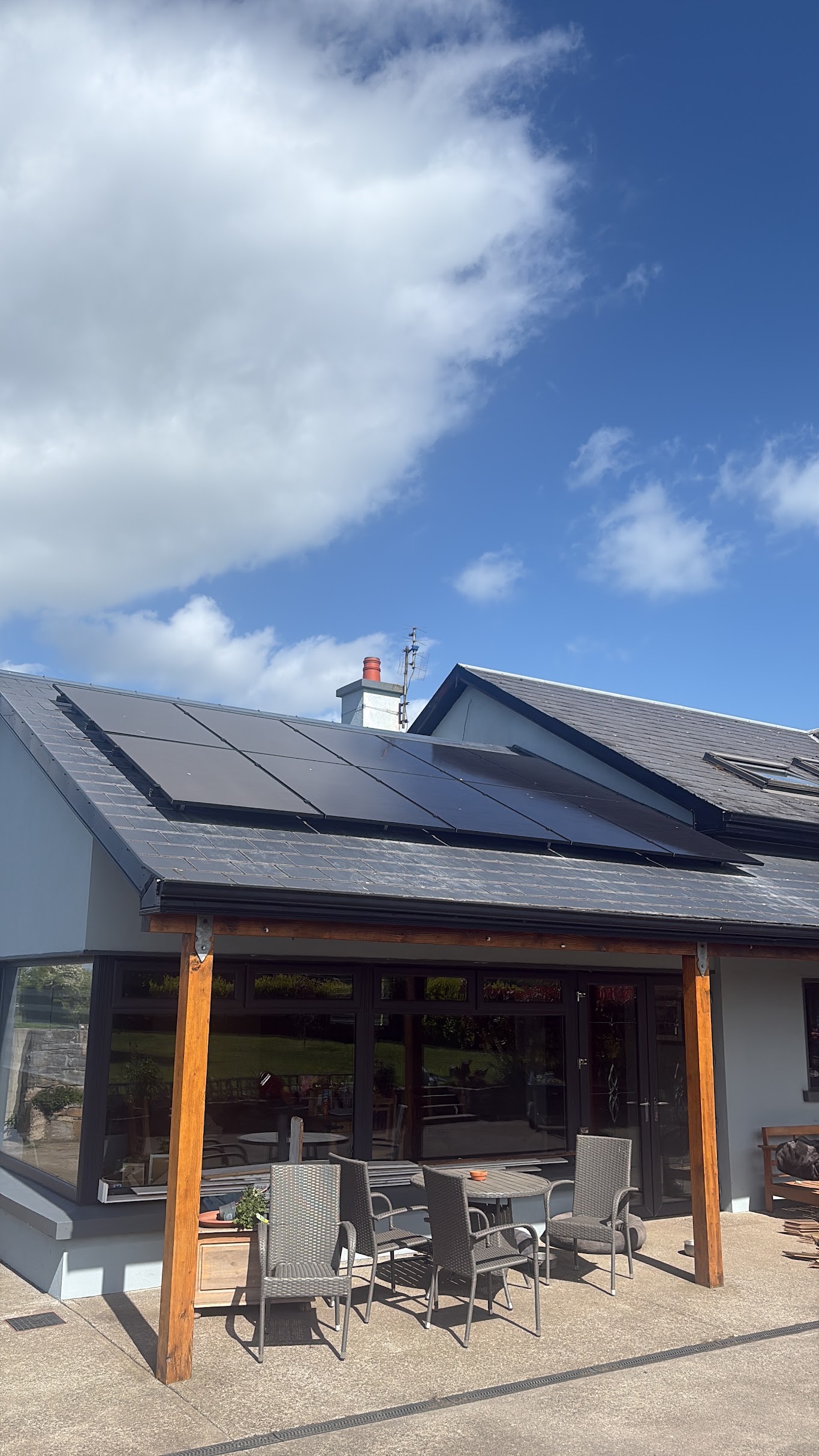 All-black solar PV panels flush mounted on residential extension slate roof