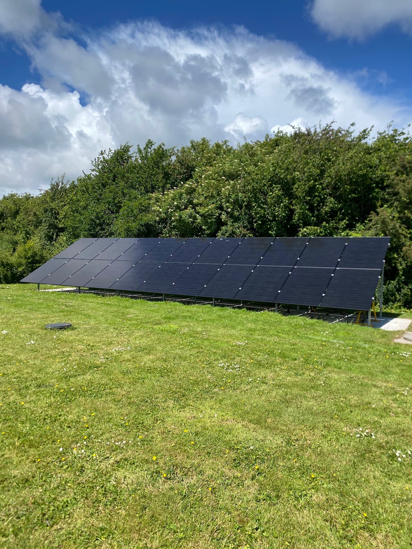 Ground-mounted solar PV array installation on open green field