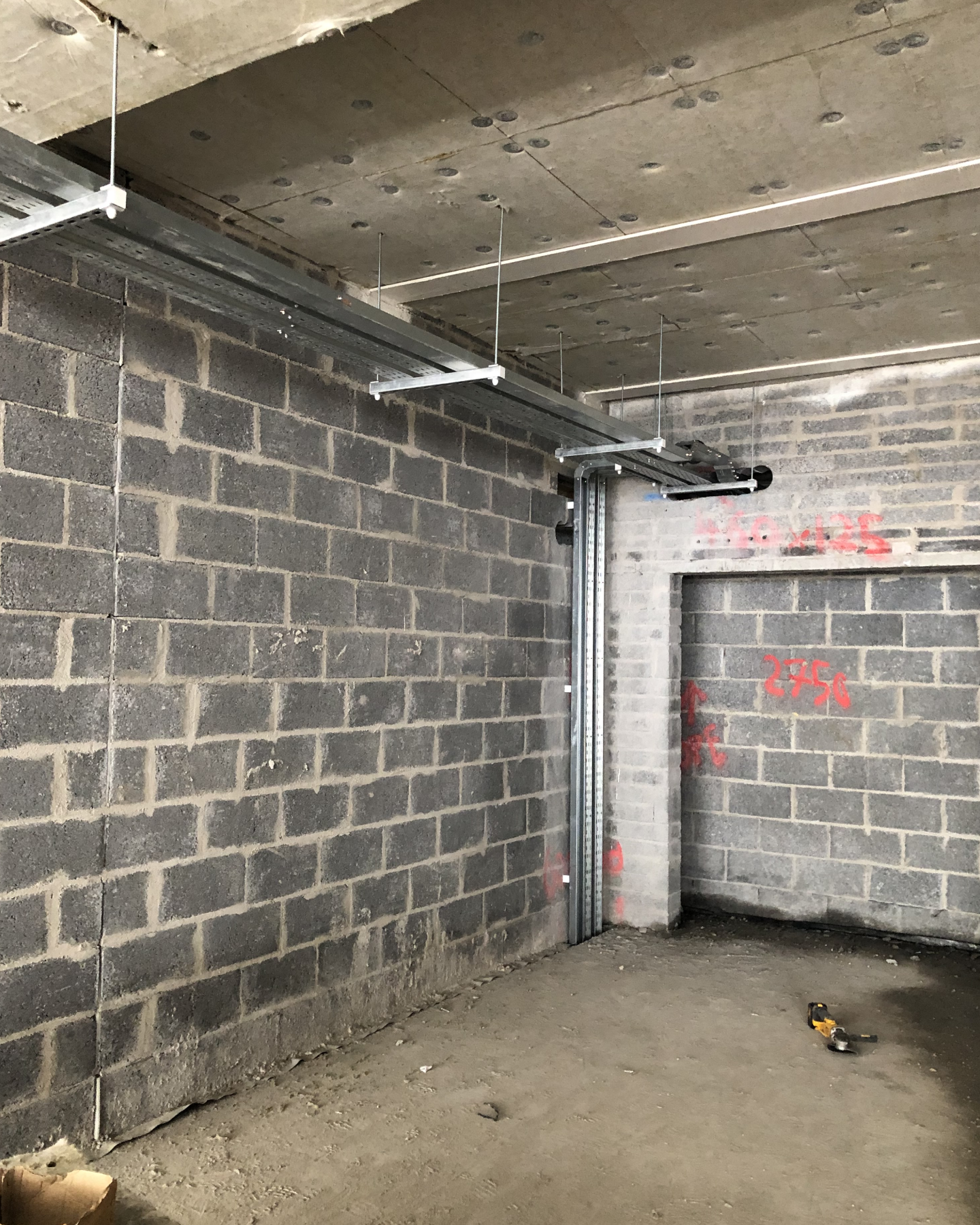 Commercial electrical containment tray and conduit installation inside a concrete block building
