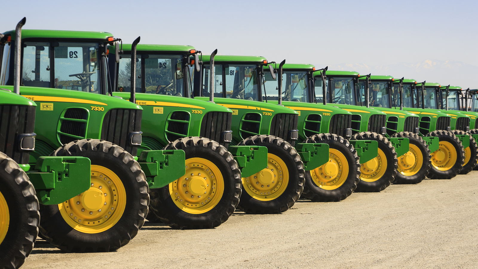 Tractors lined up on an ag equipment dealer lot.