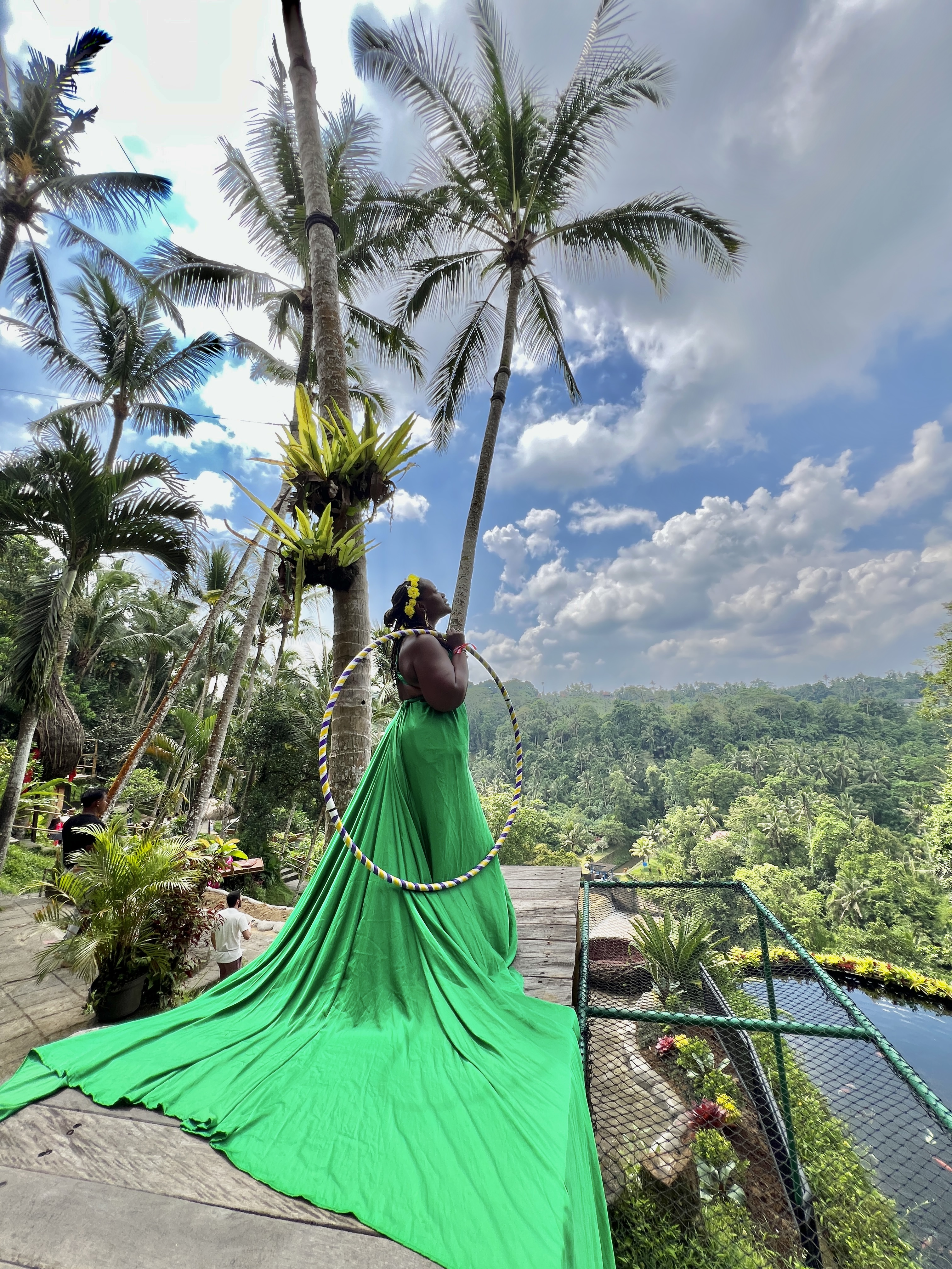 Woman in green dress with hula hoop overlooking Bali