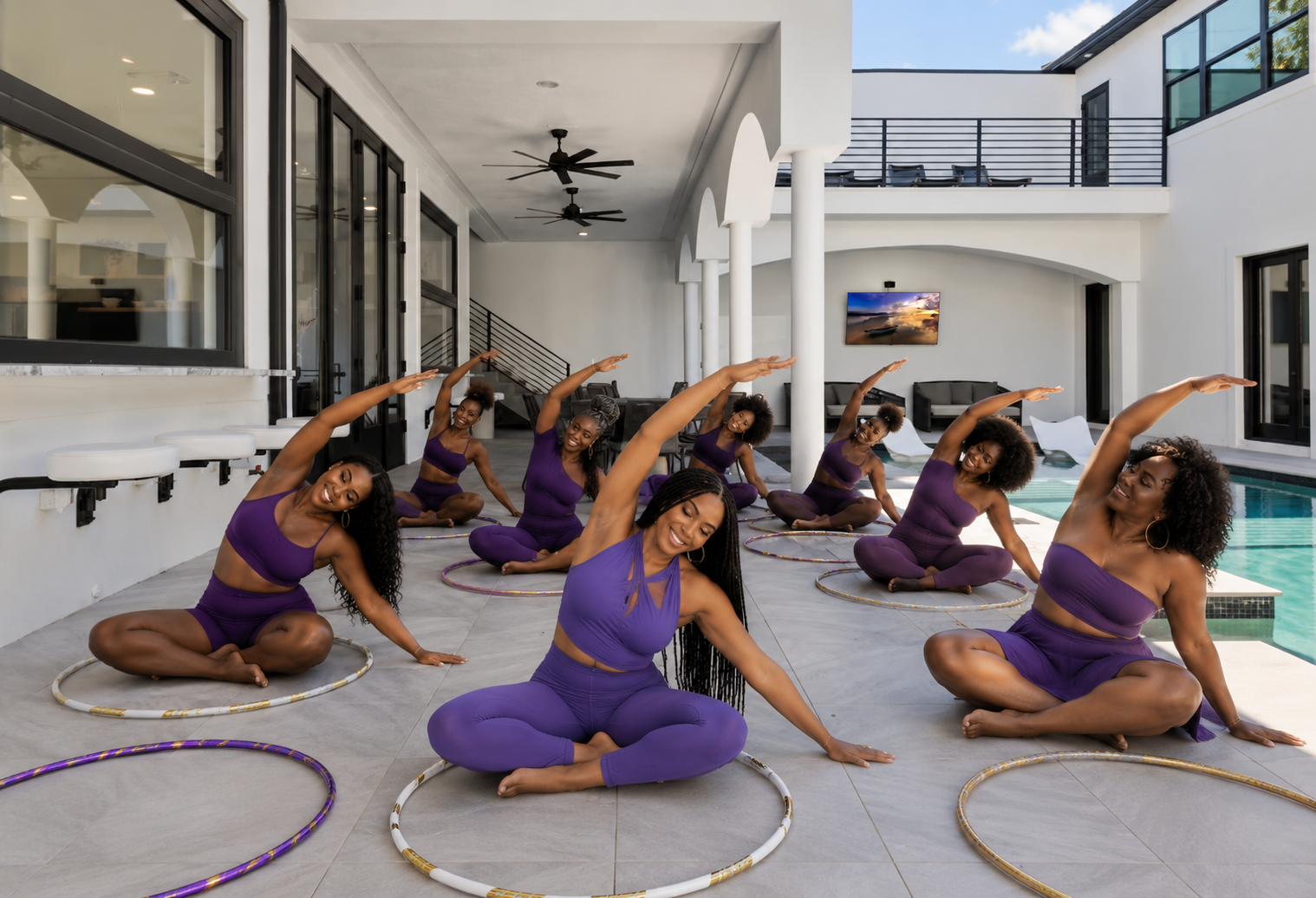 Women stretching with hula hoops by the pool