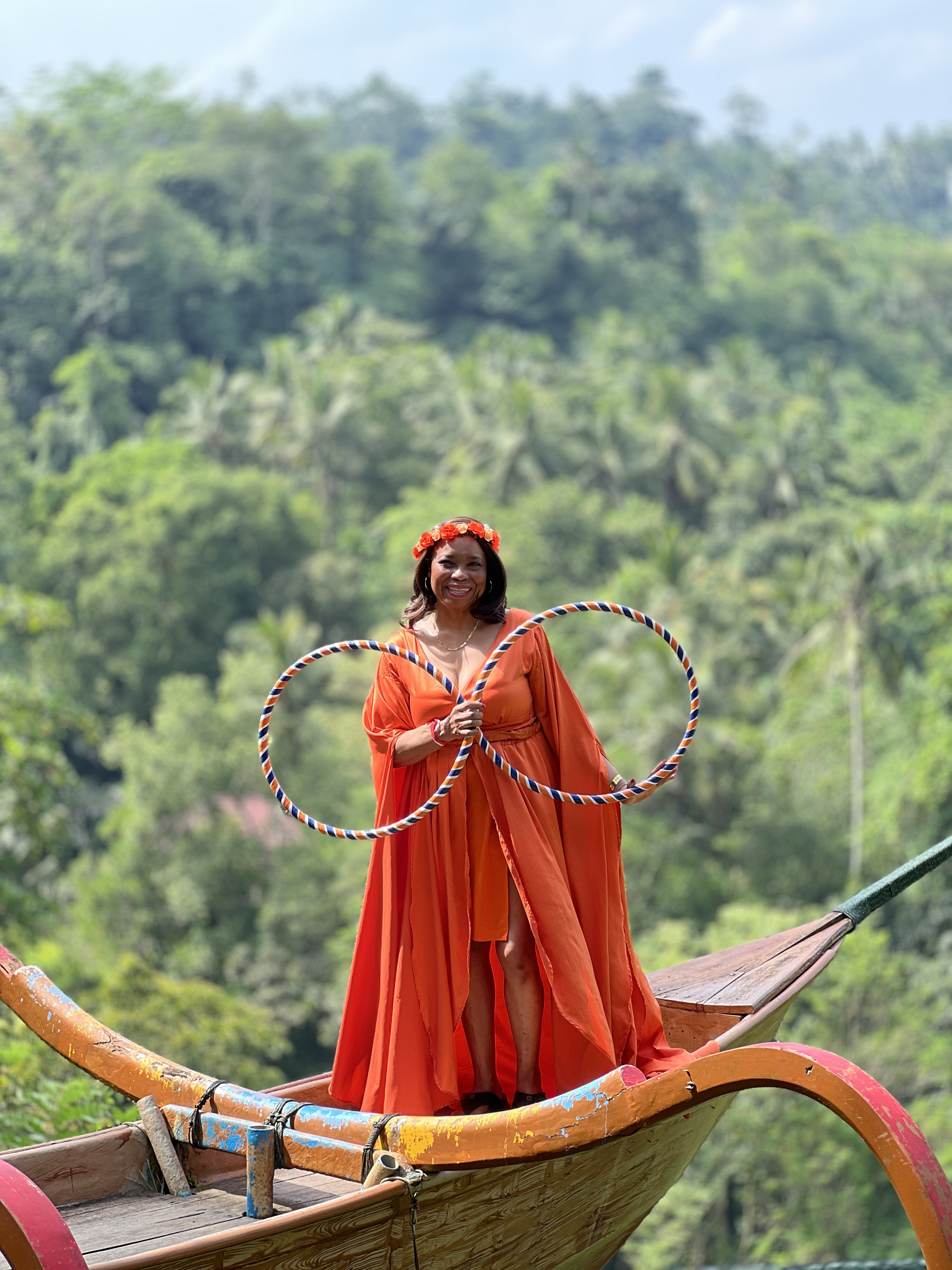 Woman in orange dress with hula hoops in Bali