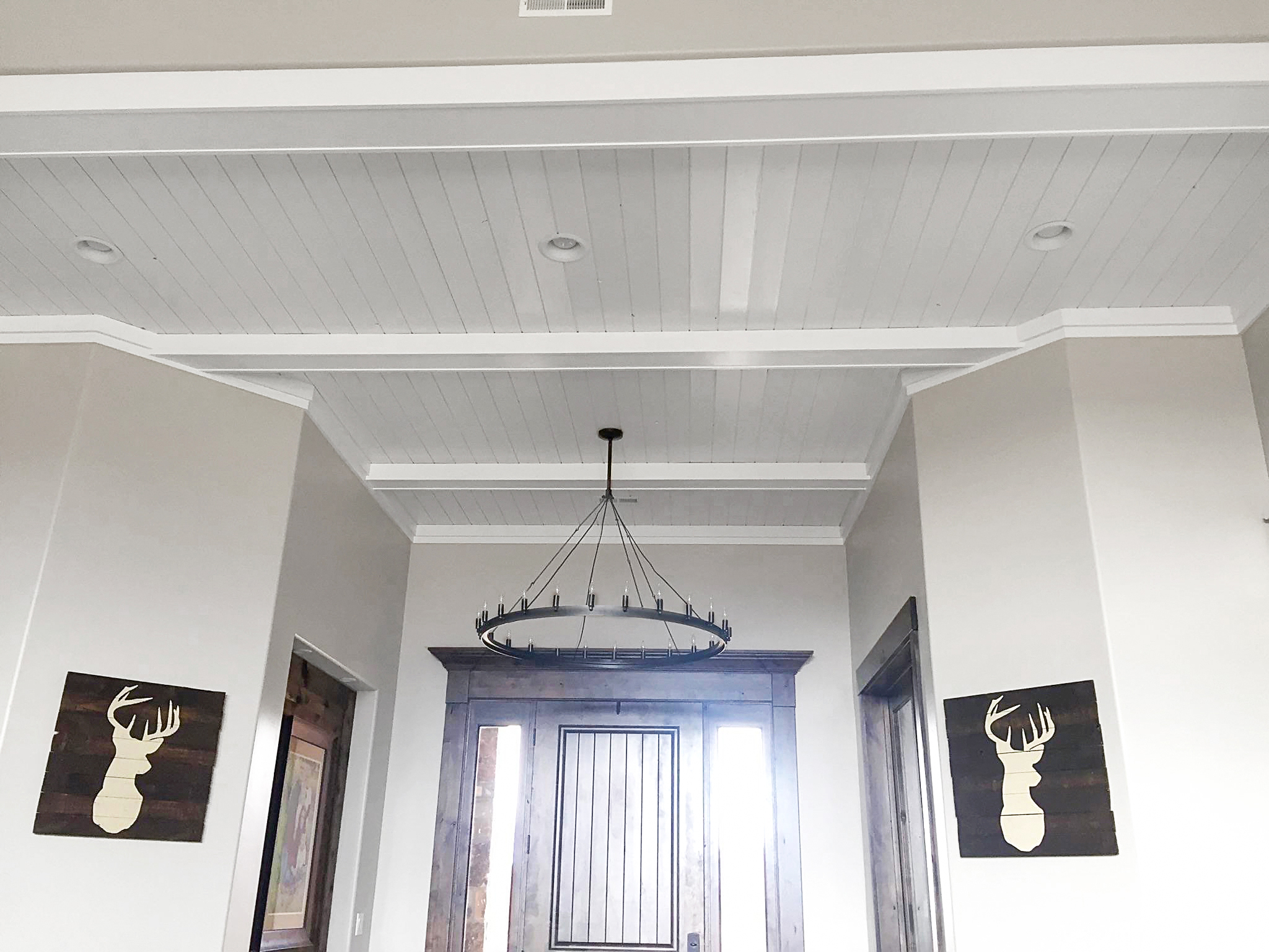 Shiplap tongue-and-groove ceiling with decorative white cross beams