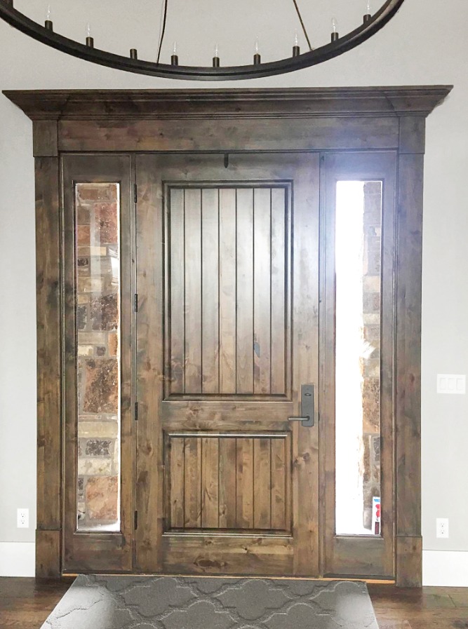 Custom wooden front door with side windows and trim