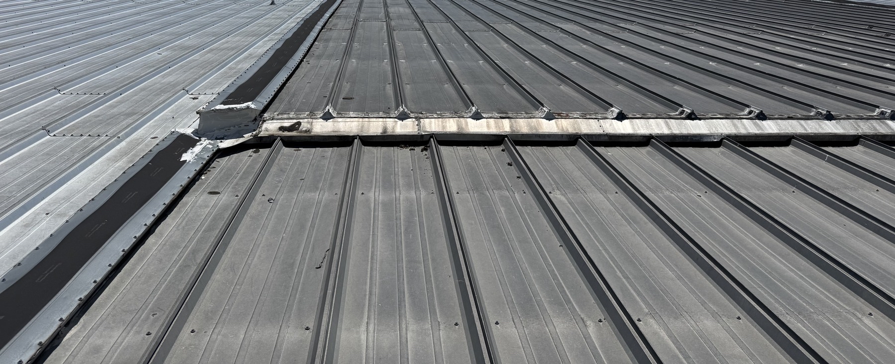 Metal roof panels with an existing transverse transition across the roof