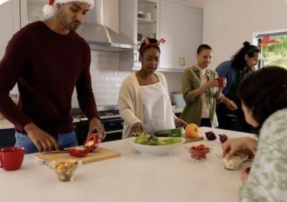 Family and friends cooking together in an open kitchen.