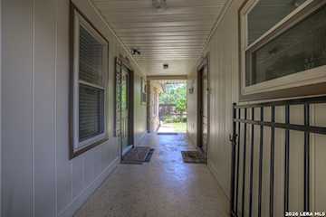 Rear yard view showing mature oaks and rock exterior architecture