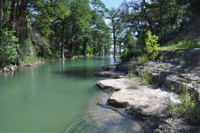 Serene riverfront view in the Texas Hill Country, perfect for nature lovers and outdoor enthusiasts