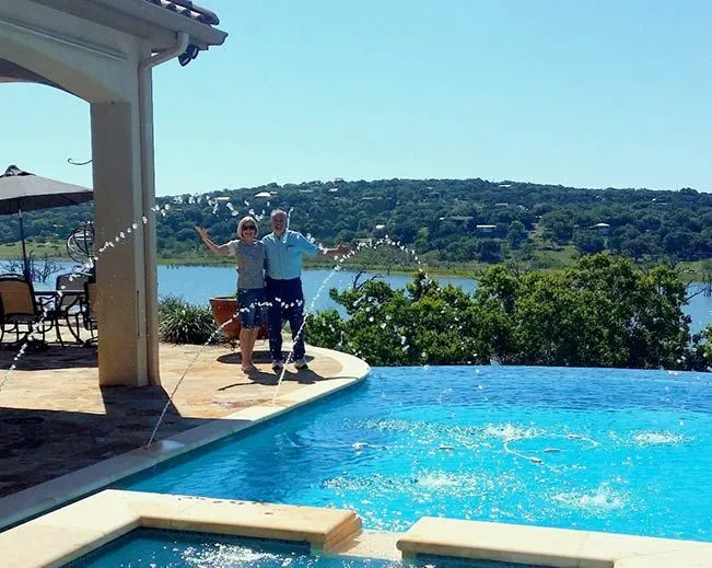 Happy couple enjoying a luxurious infinity pool overlooking the Texas Hill Country and Canyon Lake