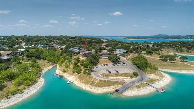 Aerial view of Canyon Lake shoreline featuring a boat ramp, parking area, and nearby lakeside homes