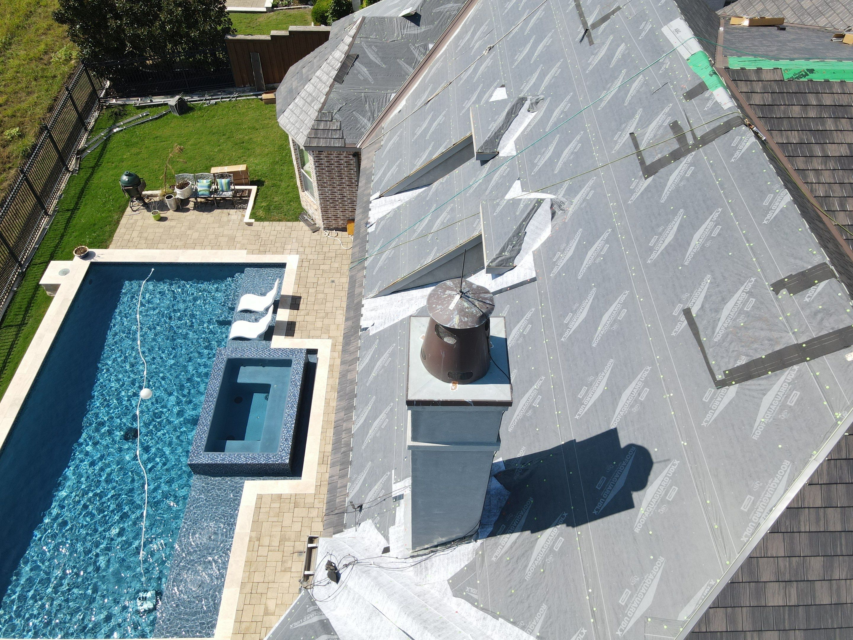 Metal roof underlayment and installation in progress near poolside