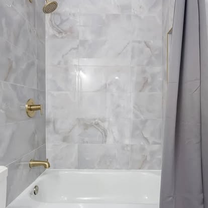 Light Grey Marble Shower with Gold Fixtures Light Grey Marble Shower with Gold Fixtures - Bathroom Remodeling by Builders For You Construction in Yuma, AZ