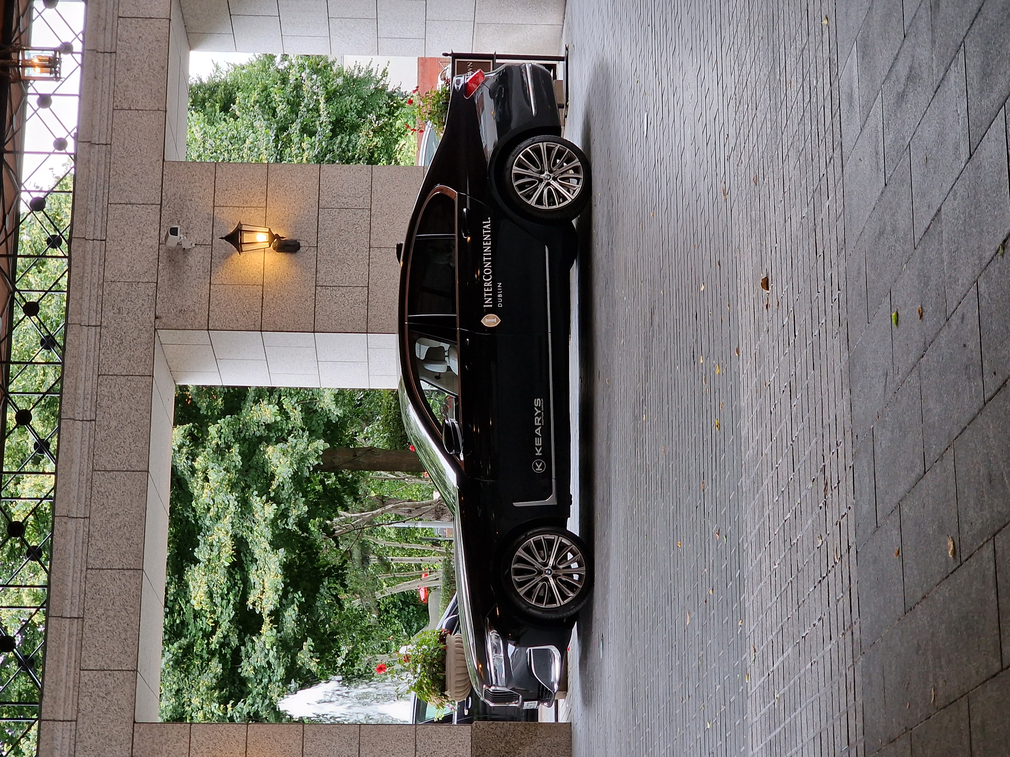 Luxury car at a premium hotel, showcasing travel perks