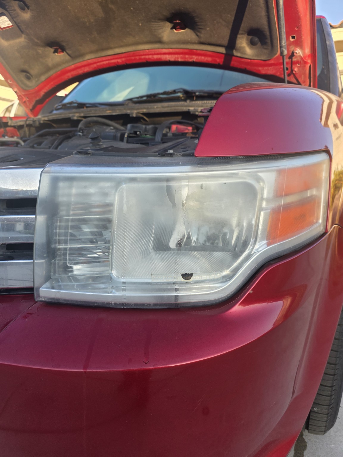 Oxidized Ford Flex headlight before restoration in Riverside, CA