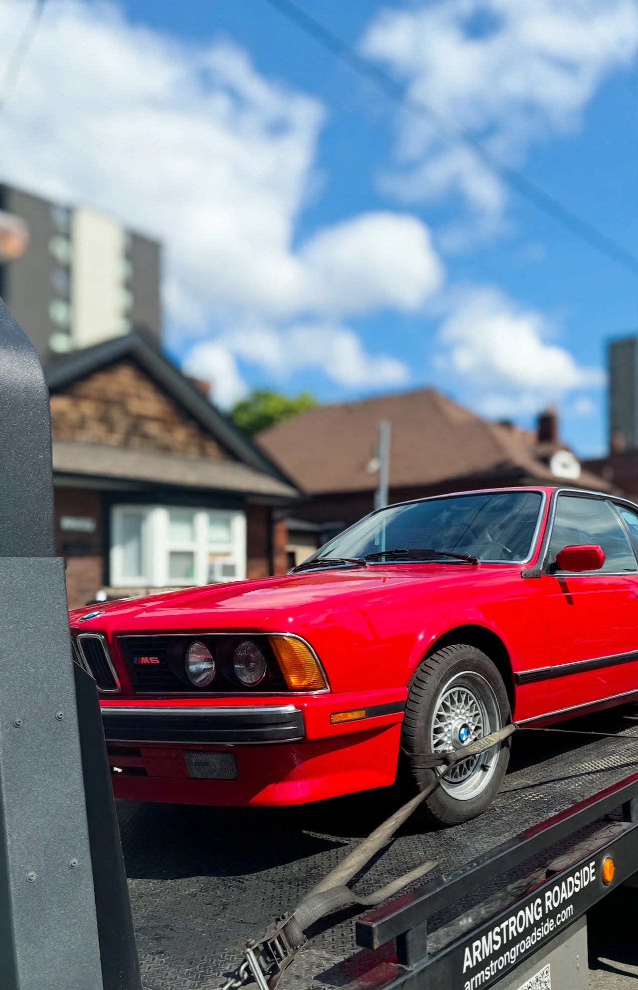 Red classic BMW on flatbed tow truck