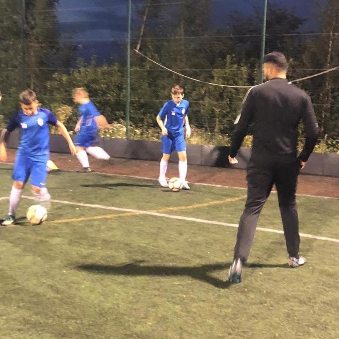 Football coach working with young players during a training session
