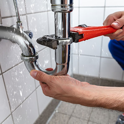 Plumber working on domestic pipe connection