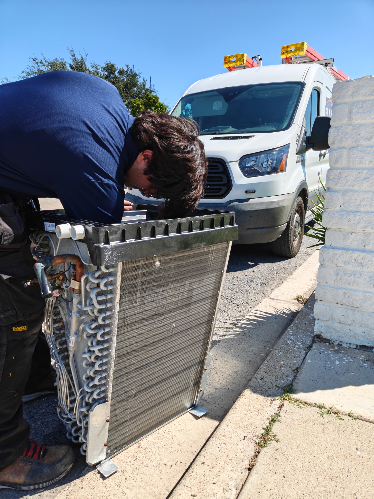 Alpha HVAC Technician Servicing Evaporator Coil in Front of Fleet Van — McAllen, TX
