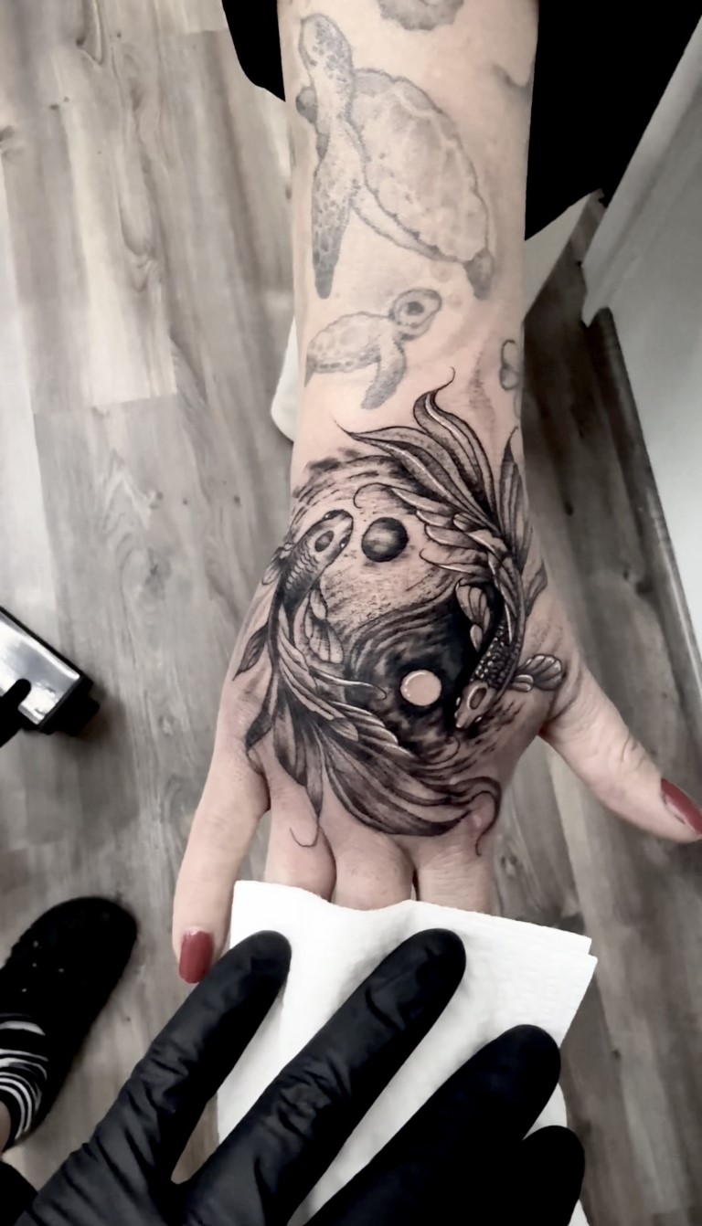 Realistic back of hand yin yang koi Tattoo Studio Salzburg 23