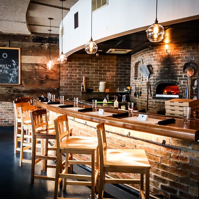The open wood-fired oven and bar seating at Forno Osteria + Bar in Hyde Park.