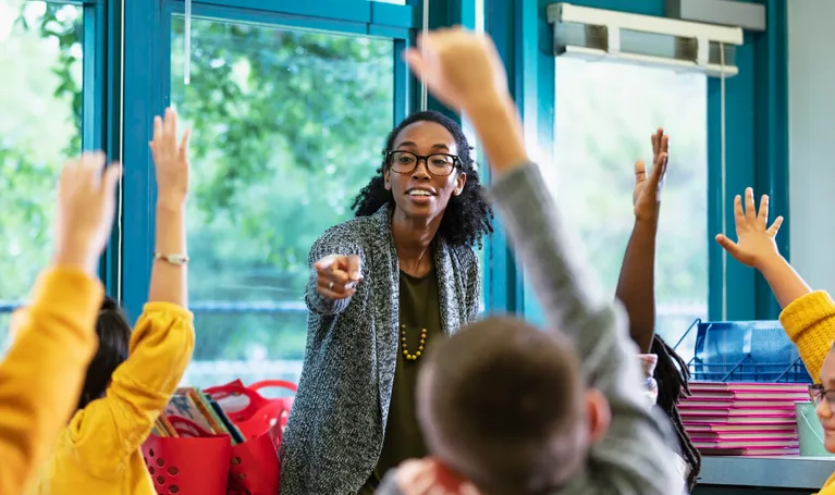 Teacher engaging with excited students in classroom