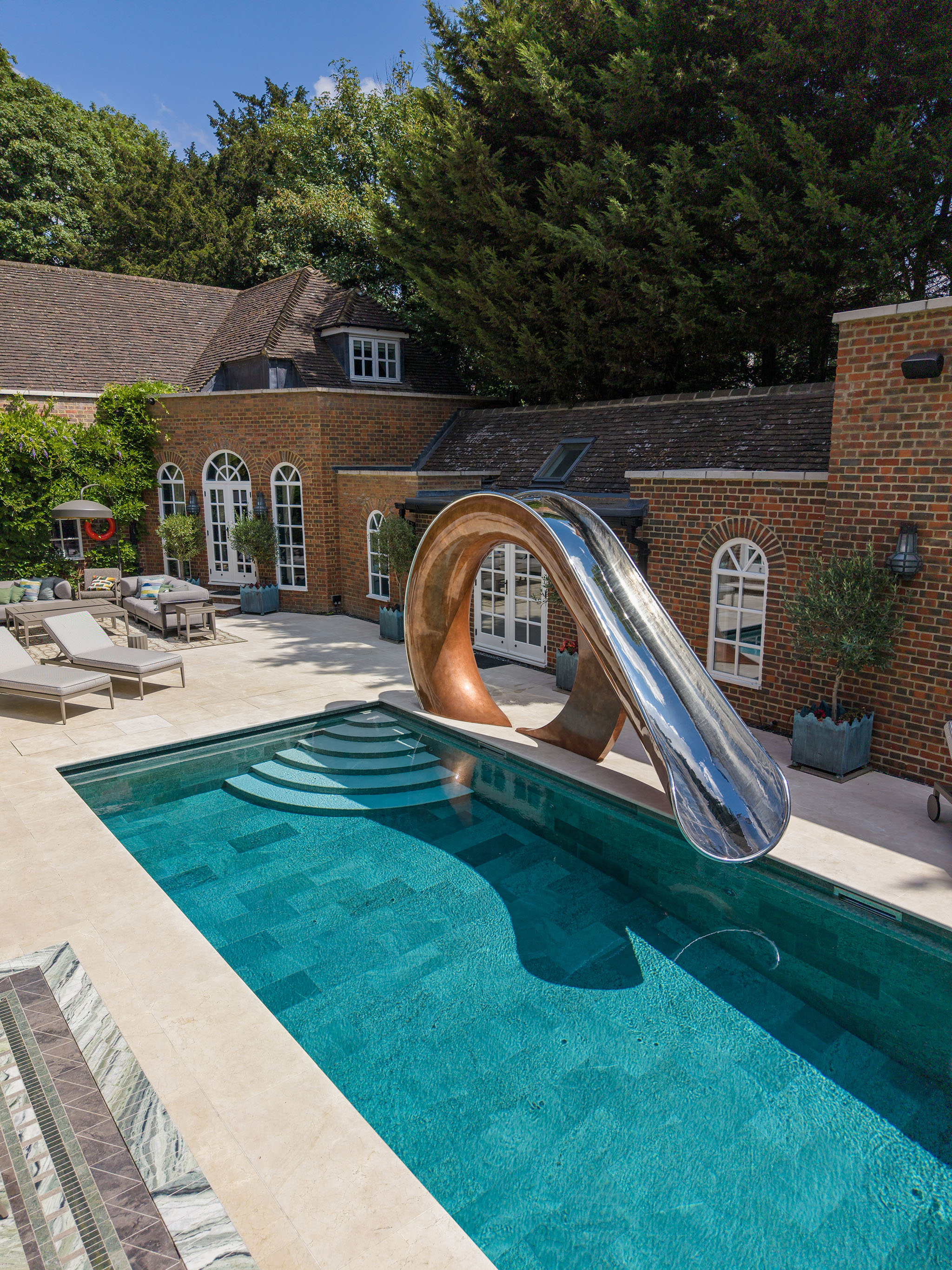 Custom residential swimming pool and architectural slide by Poolcourt