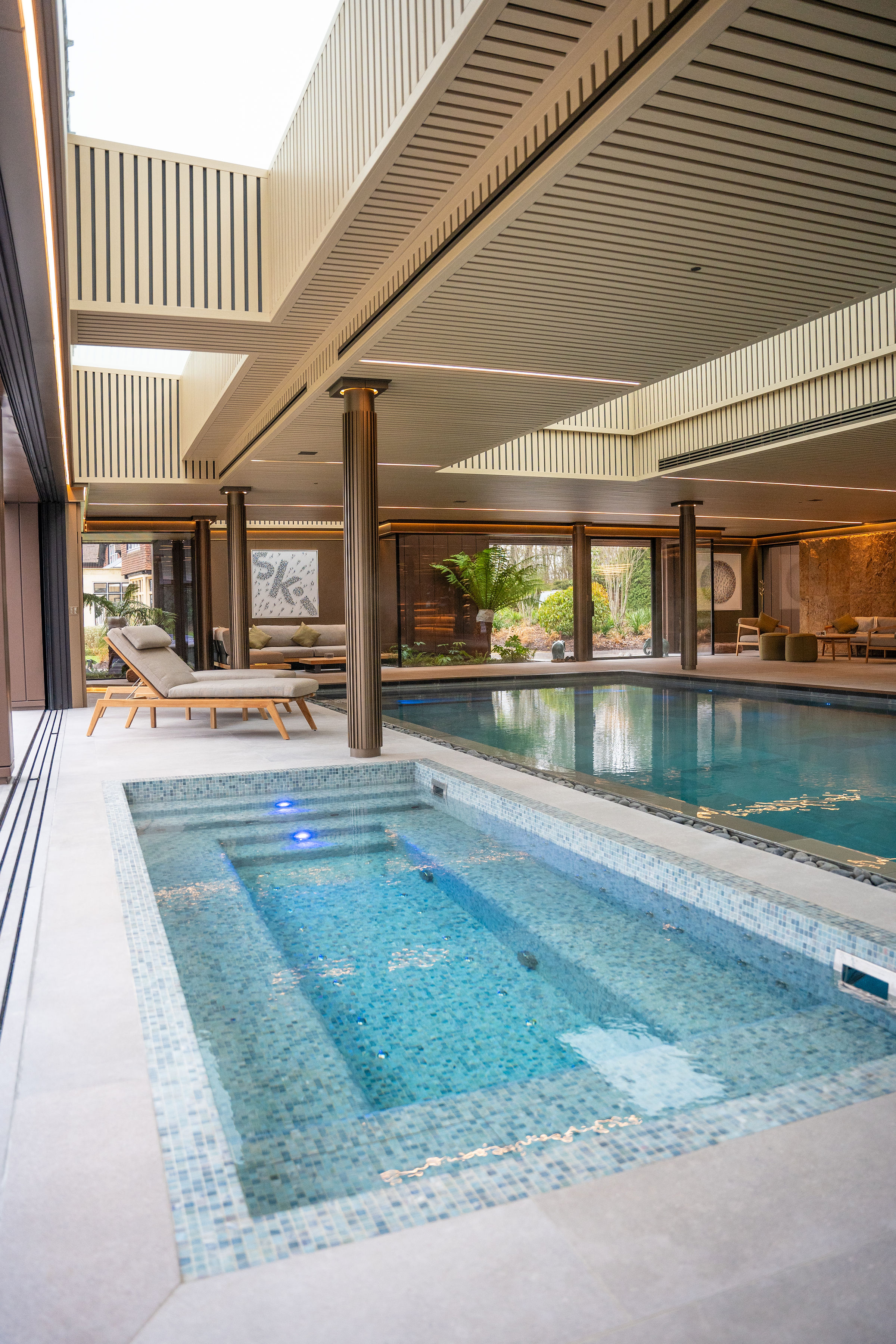 Luxury indoor swimming pool with integrated mosaic vitality spa and skylight by Poolcourt