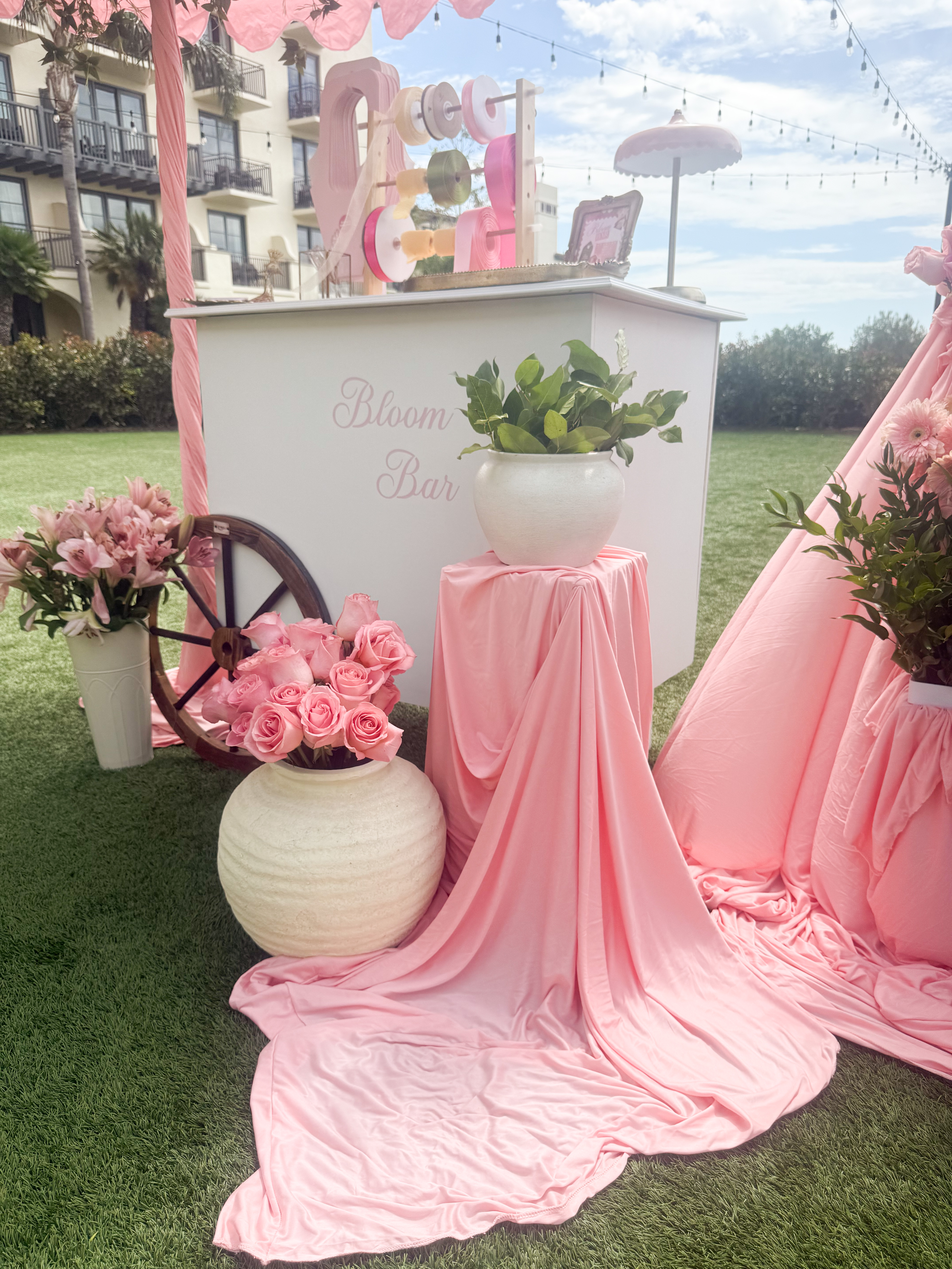 Bloom Bar cart with draped pink fabric, fresh roses, and styled ceramic vases